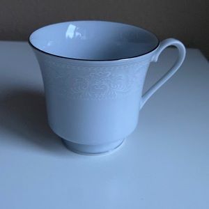White teacup with white lace pattern